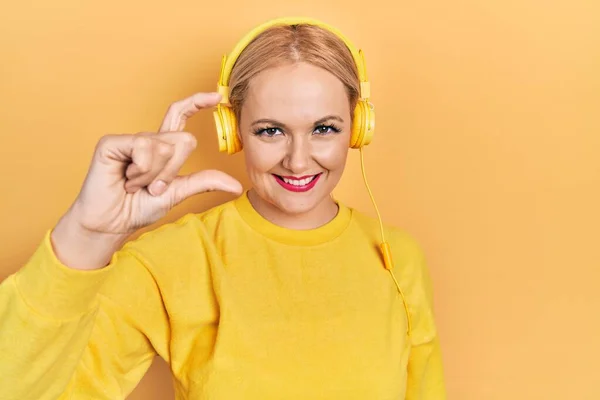 Young Blonde Woman Listening Music Using Headphones Smiling Confident Gesturing —  Fotos de Stock