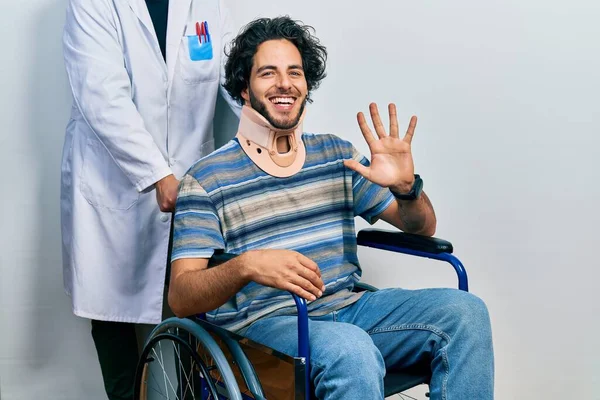 Handsome Hispanic Man Sitting Wheelchair Wearing Neck Collar Showing Pointing — kuvapankkivalokuva