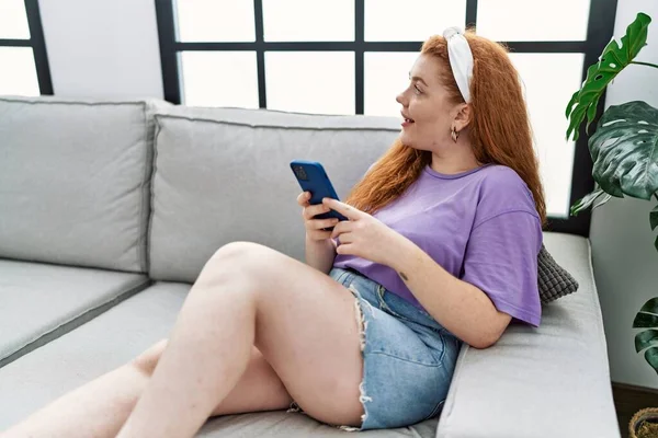 Junge Rothaarige Frau Lächelt Selbstbewusst Mit Smartphone Hause — Stockfoto