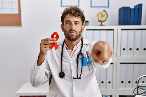 Jovem Médico Hispânico Homem Segurando Apoio Fita Vermelha Clínica Médica — Fotografia de Stock