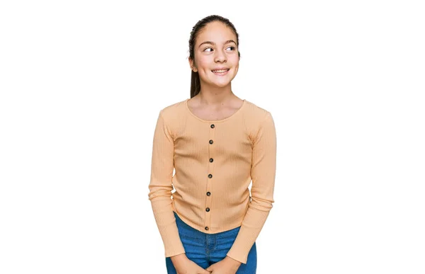 美しいブルネットの女の子が顔に笑顔で横に見えるカジュアルなセーターを着て 自然な表情 自信を持って — ストック写真
