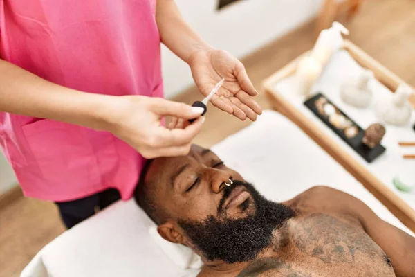 若いアフリカ系アメリカ人男性が美容センターで肌の治療を受けています — ストック写真
