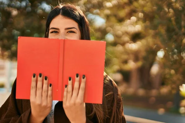Joven Mujer Hispana Sonriendo Feliz Cubriendo Cara Con Libro Ciudad —  Fotos de Stock