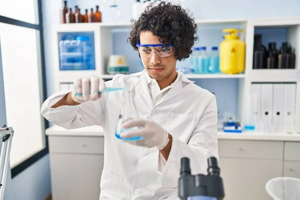 Joven Hispano Vistiendo Uniforme Científico Vertiendo Líquido Tubo Ensayo Laboratorio — Foto de Stock