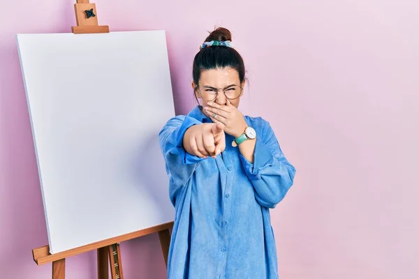 Young Hispanic Woman Standing Painter Easel Stand Laughing You Pointing — ストック写真