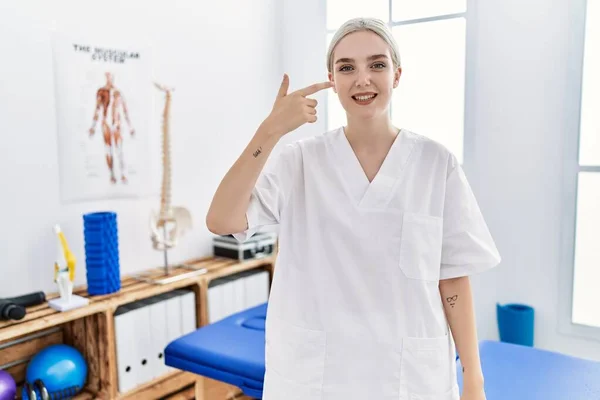 Young Caucasian Woman Working Pain Recovery Clinic Pointing Hand Finger — Stockfoto
