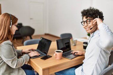 Ofiste çalışırken gülümseyen iki çağrı merkezi ajanı..