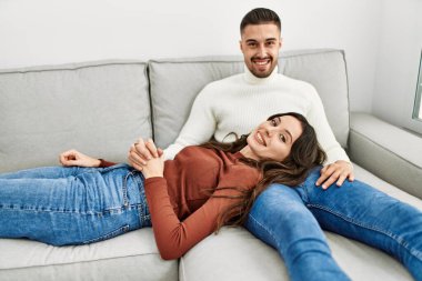 Genç İspanyol çift kanepede ve evde sarılıp dinleniyorlar..