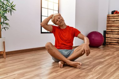 Spor merkezinde kendine güvenen, gülümseyen beyaz bir genç.