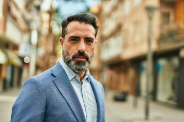 Şehirde duran rahat yüzlü orta yaşlı iş adamı..