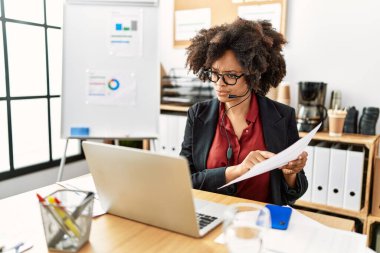 Genç Afro-Amerikan kadın çağrı merkezi ajanı ofiste video görüşmesi yapıyor.