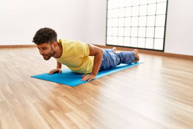 Genç Arap sporcu spor merkezinde karın kaslarını çalıştırmaya odaklan..