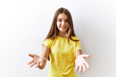 Young brunette teenager standing together over isolated background smiling cheerful offering hands giving assistance and acceptance. 