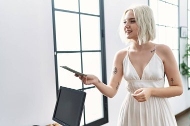 Beyaz kadın gülümsüyor. Dolarla ödeme yapıyor.