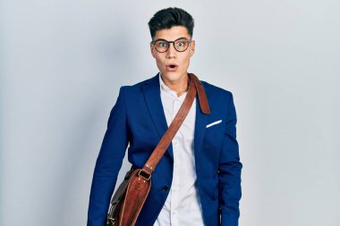 İş kıyafetleri giymiş genç İspanyol bir adam. Şaşırmış ve korkmuş bir ifade, korku ve heyecanlı bir yüz ifadesi var.. 