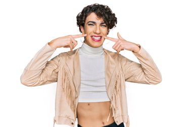 Handsome man wearing make up and woman clothes smiling cheerful showing and pointing with fingers teeth and mouth. dental health concept. 