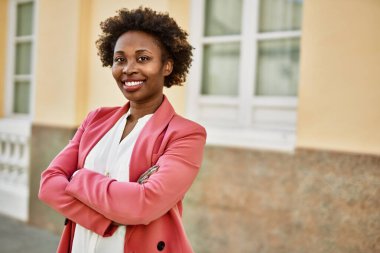 Güzel bir iş adamı Afro saçlı Amerikalı kadın şehirde mutlu ve kendinden emin bir şekilde gülümsüyor.