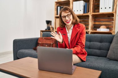 Beyaz kadın psikolog psikoloji merkezinde online danışmanlık yapıyor.