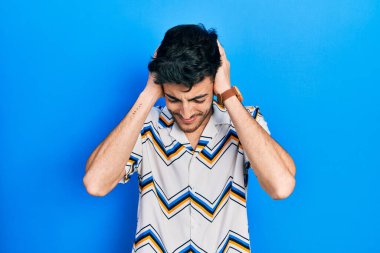İspanyol asıllı genç adam gündelik giysiler giyiyor. Baş ağrısı çekiyor. Acı ve migren yüzünden çaresiz ve stresli. Eller başının üstünde.. 