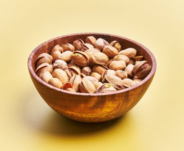  Sarı arka planda bir kase fıstık.