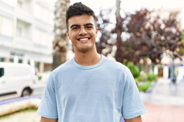 Sokakta kendinden emin gülümseyen İspanyol genç adam.