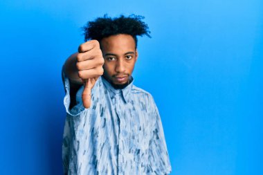 Young african american man with beard wearing casual clothes looking unhappy and angry showing rejection and negative with thumbs down gesture. bad expression. 