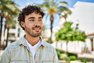 Yakışıklı, sakallı, güneşli bir günde mutlu bir şekilde gülümseyen bir İspanyol.