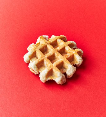  Kırmızı arka planda tek lezzetli waffle.