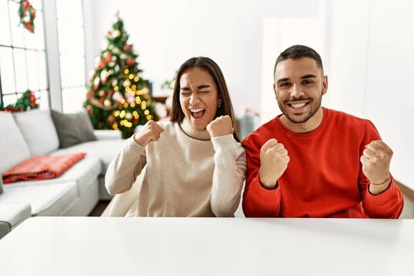 Young Hispanic Couple Sitting Table Christmas Tree Very Happy Excited — Zdjęcie stockowe