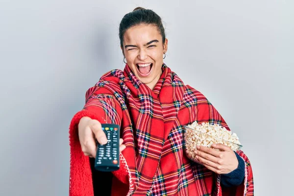 Young Caucasian Girl Wearing Blanket Eating Popcorn Using Control Winking — Stock Photo, Image