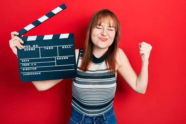 Rudowłosa Młoda Kobieta Trzyma Film Wideo Clapboard Krzycząc Dumny Świętując — Zdjęcie stockowe
