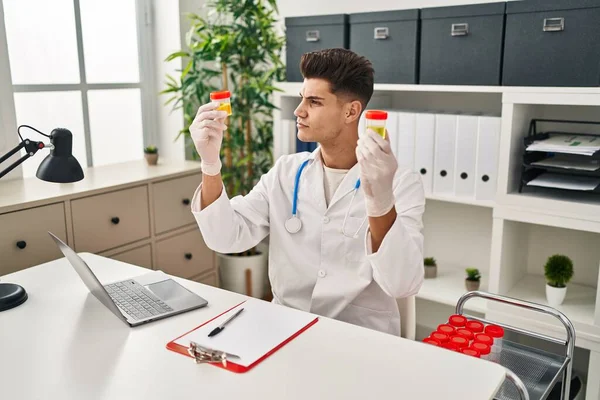 Young Hispanic Man Wearing Doctor Uniform Analysing Urine Test Tubes — ストック写真