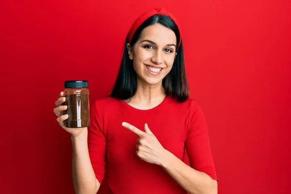 Young Hispanic Woman Holding Soluble Coffee Smiling Happy Pointing Hand — ストック写真