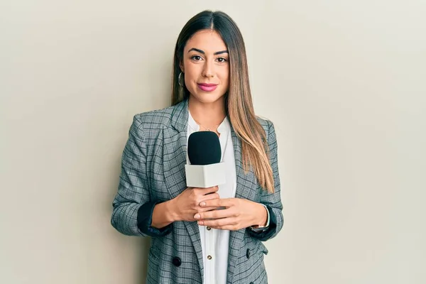 Young Hispanic Woman Holding Reporter Microphone Thinking Attitude Sober Expression — Stock Photo, Image