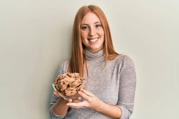 Young Irish Woman Holding Bowl Chocolate Chips Cookies Looking Positive — 图库照片
