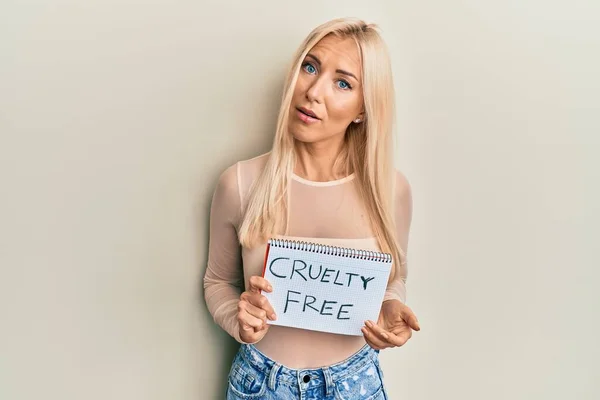 Young Blonde Woman Holding Cruelty Free Message Banner Clueless Confused — Fotografia de Stock