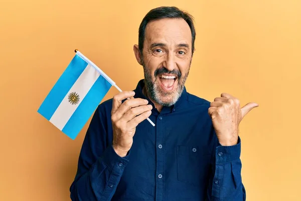 Middle Age Hispanic Man Holding Argentina Flag Pointing Thumb Side — 스톡 사진