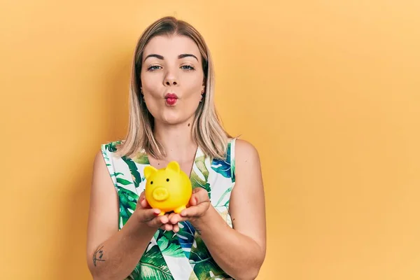 Beautiful Caucasian Woman Holding Piggy Bank Making Fish Face Mouth — Stockfoto