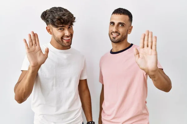 Young Gay Couple Standing Isolated Background Waiving Saying Hello Happy — Fotografia de Stock