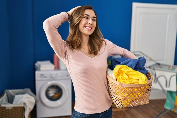 Young Woman Holding Laundry Basket Smiling Confident Touching Hair Hand — Stockfoto