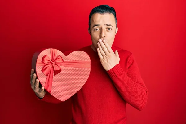 Handsome Young Man Holding Valentine Gift Covering Mouth Hand Shocked — Φωτογραφία Αρχείου