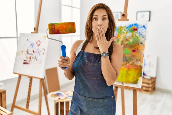 Young Latin Artist Woman Holding Paint Roller Standing Art Studio — стоковое фото