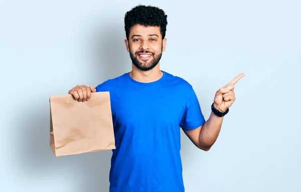 Jovem Árabe Homem Com Barba Segurando Tirar Saco Papel Sorrindo — Fotografia de Stock