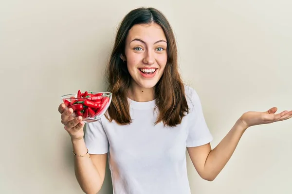 Joven Morena Sosteniendo Pimientos Rojos Celebrando Logro Con Sonrisa Feliz —  Fotos de Stock