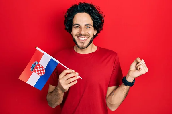 Handsome Hispanic Man Holding Croatia Flag Screaming Proud Celebrating Victory — Stockfoto