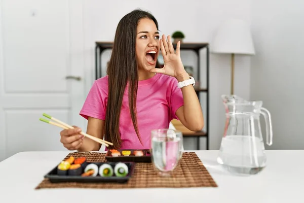 Young Brunette Woman Eating Sushi Using Chopsticks Shouting Screaming Loud — 图库照片