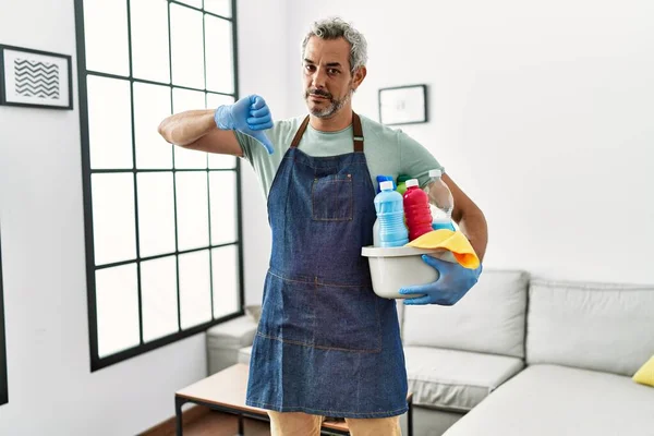 Middle Age Hispanic Man Wearing Cleaner Apron Holding Cleaning Products — 图库照片