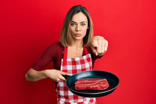 Νεαρή Καυκάσια Ξανθιά Γυναίκα Που Φοράει Μαγειρεμένη Ποδιά Μαγειρεύοντας Κρέας — Φωτογραφία Αρχείου