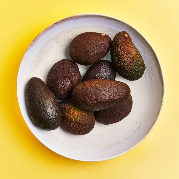 Sarı Arka Planda Bir Kase Avokado Meyvesi — Stok fotoğraf