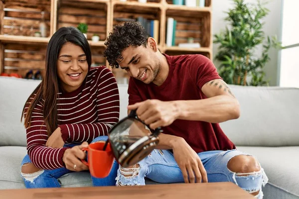 Young Latin Couple Smiling Happy Drinking Coffee Sitting Sofa Home — Foto Stock